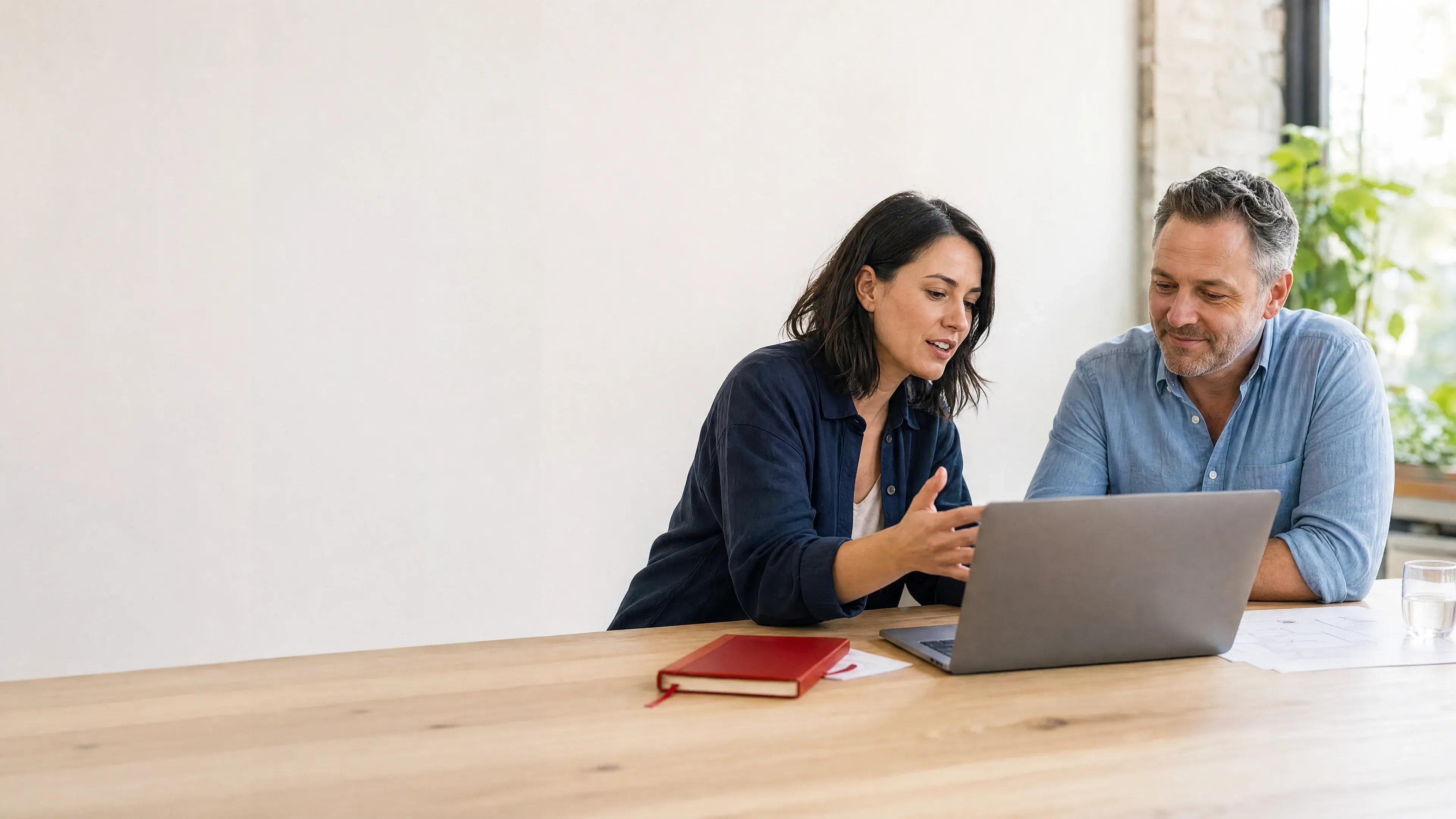 Gründerin und Coach besprechen gemeinsam einen Businessplan am Laptop